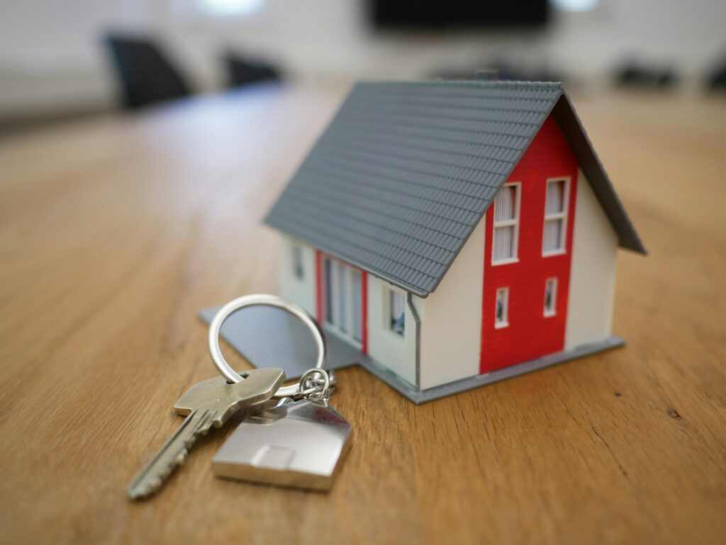 Small model home with a key on a keychain.