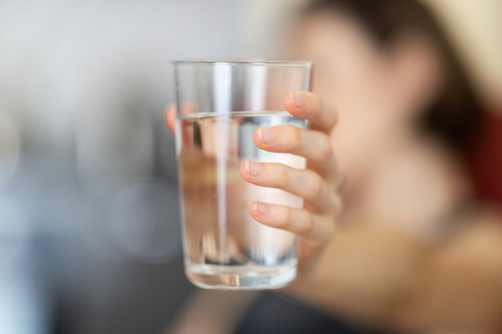 Hand holding a glass of water.