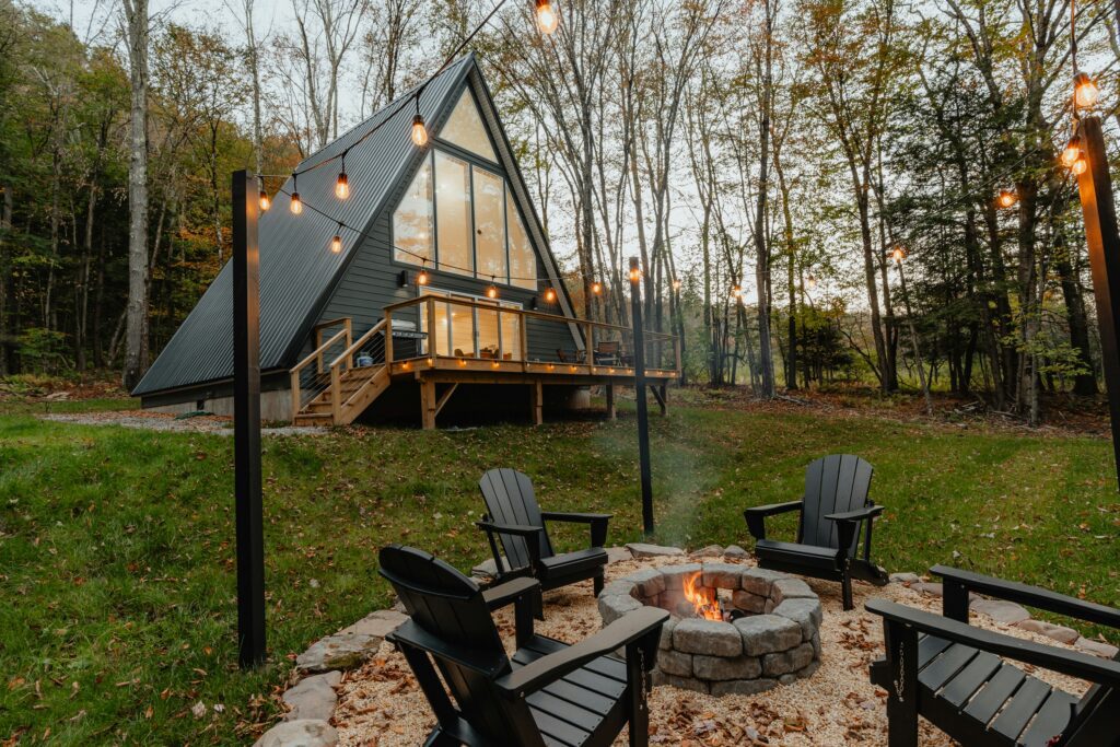 A beautiful A Frame house with a fire pit in the yard.
